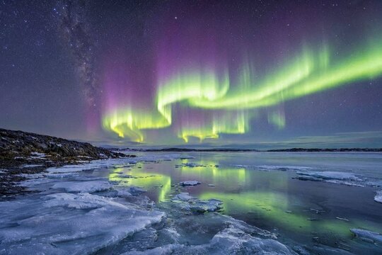 Brilliant aurora borealis dancing across a star-filled Arctic sky