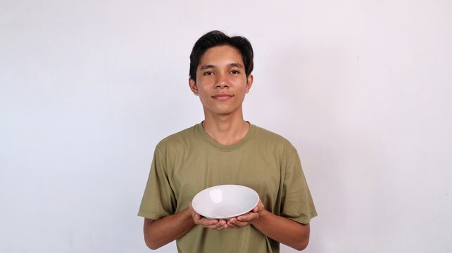 young asian man holding empty bowl
