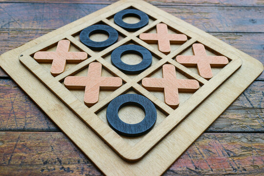 Close up of a vintage wooden tic tac toe board game symbolizing strategic thinking, decision making, competition, leadership, problem solving, education, teamwork and business success concepts.