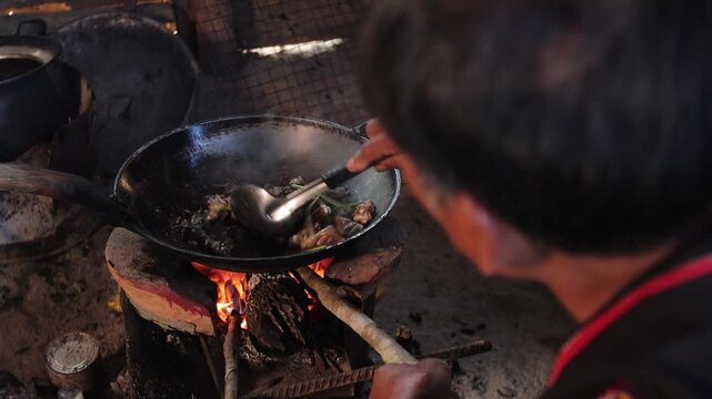 Authentic Thai hill tribe home kitchen where traditional local food is being prepared using simple cooking methods and fresh natural ingredients. This rustic scene highlights indigenous culinary tradi