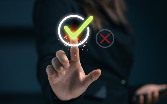 Businesswoman confirming a digital verification with a virtual checkmark icon, representing successful validation, quality assurance, online approval, compliance, and secure business processes.