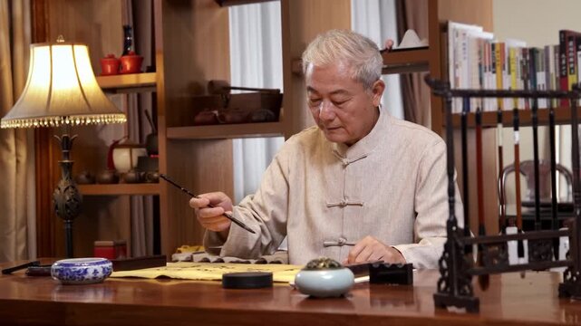 The calligrapher artist practicing traditional calligraphy with ink brush, writing on a scroll on aged parchment paper at a wooden desk in a studio, creative hobby and lifelong learning in retirement