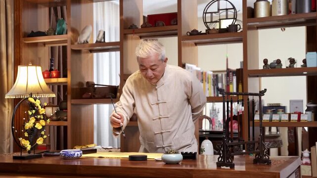 Elderly calligrapher artist practicing traditional calligraphy with ink brush, writing on a scroll on aged parchment paper at wooden desk in studio, creative hobby and lifelong learning in retirement