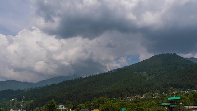 4K Time lapse shot of dark monsoon clouds above the Pine Tree forest during the monsoon season as seen from Naggar near Manali in Himachal Pradesh, India. Scenic view of clouds in Himalayas.
