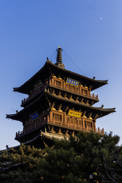 Ancient wooden pagoda of Huayan Temple under clear blue sky with crescent moon, Datong Shanxi China