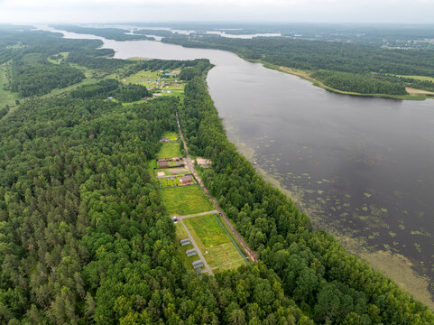 Aerial view of a small holiday resort and sub-divided land plots by a quiet forest lake on an overcast summer day in Karelia, Russia