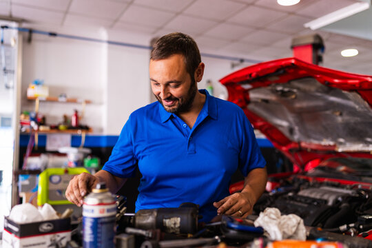 Mechanic smiling while working in auto repair shop
