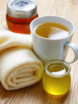 Warm tea honey jar mug scarf wooden table cream scarf still life cold care winter comfort cozy scene