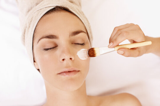 Hands, facial and brush with woman in spa for pore detox, skincare and deep cleaning cosmetics. Clay treatment, beauty glow and face mask with above of person in salon for purifying minerals
