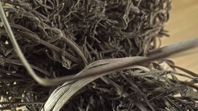 Macro close up of dried rosemary herb highlighting detailed leaf texture on wooden surface for culinary seasoning, herbal ingredients and natural food preparation