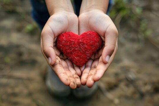 Colorful decorative heart in strong human hands on bright color