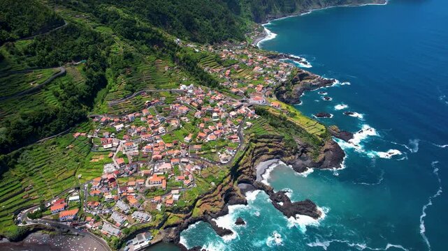 Seixal natural pools Madeira island Portugal 4K. Aerial drone downward flyover close up view of volcanic ocean pools and green village terraces. Scenic nature travel b roll cinematic footage