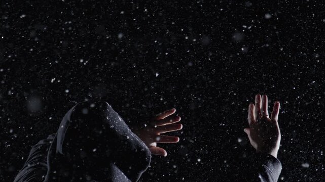 Danger figure hides in darkness. Danger gesture shows raised hand. Hooded danger concept feels scary. Snowy danger scene looks cinematic.
