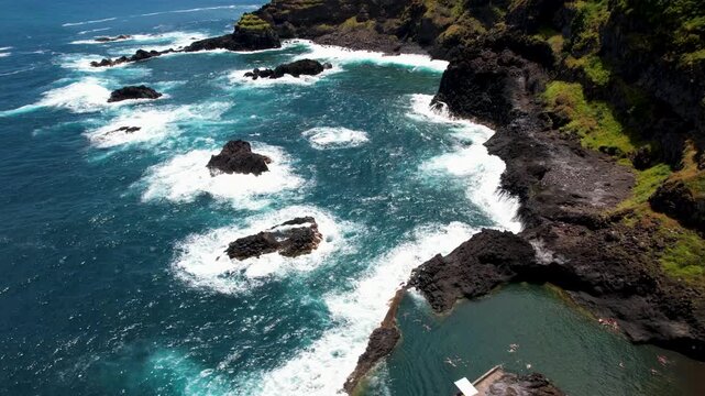 Seixal Madeira Portugal Aerial Drone Top Down View Over Lava Natural Swimming Pools Crashing Ocean Waves reveal Misty Mountains Covered in Clouds Island Coast Travel Video 4K UHD