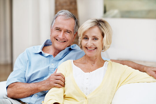 Smile, support and portrait with old couple on sofa for bonding, connection and marriage. Retirement, happy and commitment with senior man and woman in living room in house for relax, trust and care