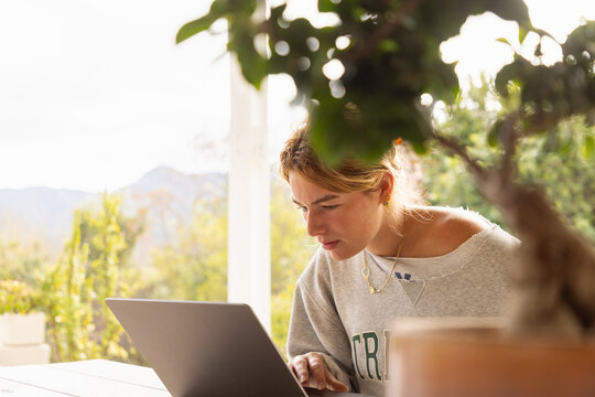 young woman using laptop computer on outdoor patio