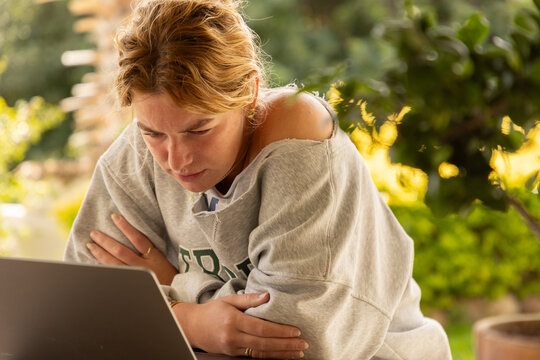 young woman using laptop computer on outdoor patio