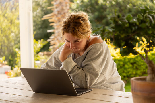 young woman using laptop computer on outdoor patio