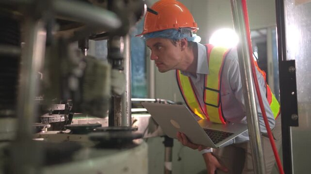 Engineer inspecting machinery with laptop in beverage production process