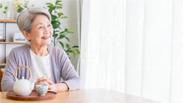 帰省する家族の到着をお茶を用意して待つシニア女性