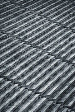 Black and white high angle diagonal view of empty stone stadium bleachers and tiered seating rows in Indonesia