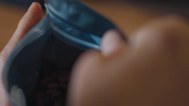 Woman opens the bag with coffee, close up view of the bag