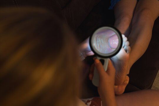  Dermatologist examining patient's fingernails for psoriasis