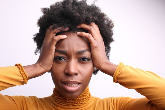 Stressed young black woman holding her head in frustration