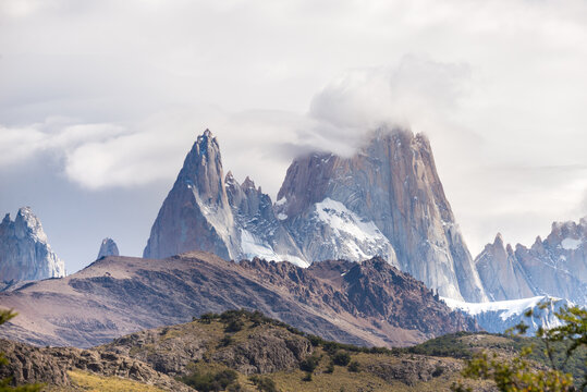 Dramatic mountain peaks with snow and clouds in a vast landscape