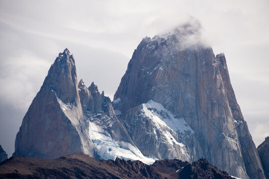 Dramatic mountain peak view, snowcapped rock face, cloudy sky