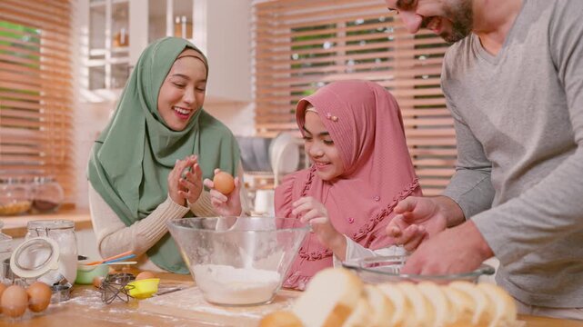 Happy Muslim family baking bakery together in kitchen at cozy home. 