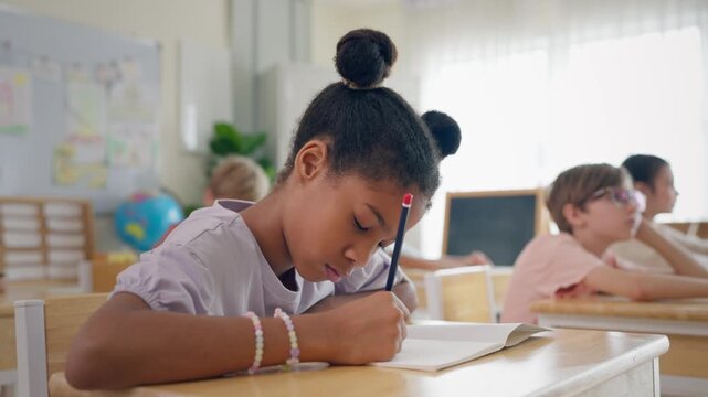 African American schoolgirl learning in classroom at elementary school. 