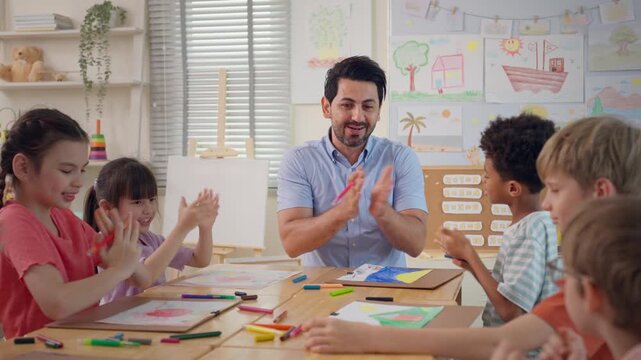 Caucasian male teacher teaching art lesson to children in classroom. 