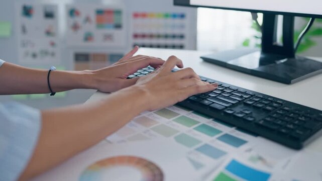 Close up of female designer working on a table in a creative workspace. 