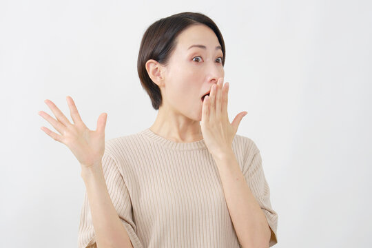 口に手を当てて驚く女性　ミドルエイジ　白背景