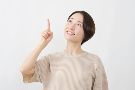 上を指差して見上げる女性　白背景
