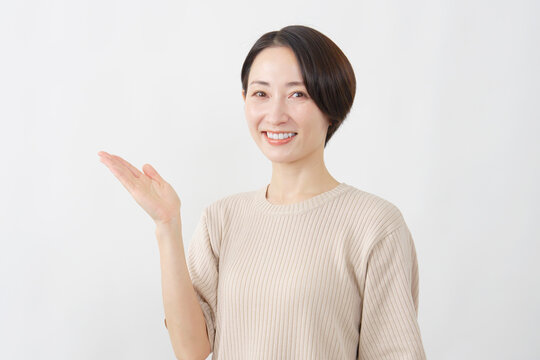 手のひらで左を案内する女性　白背景