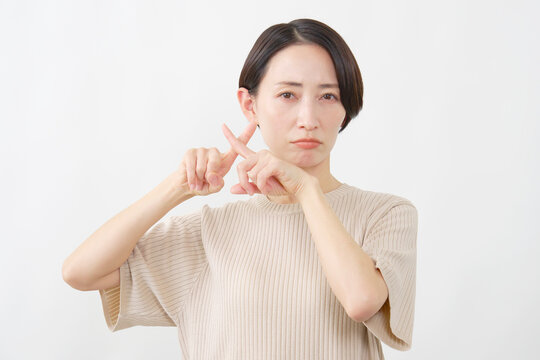 指でバツサインを示す女性　白背景