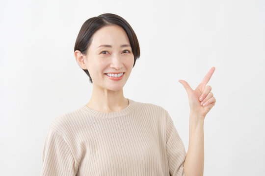 人差し指を立てる笑顔の女性　白背景