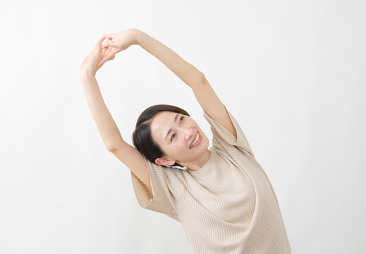 腕を伸ばして伸びをする女性　白背景