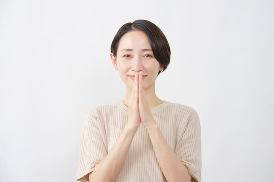 手を合わせてお願いする女性　白背景