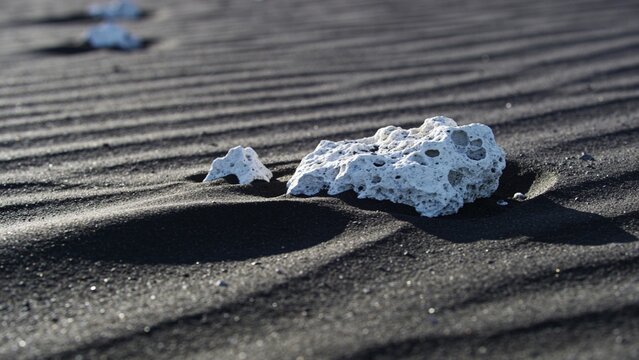 Desolate Volcanic Black Sand Dunes with Textured White Pumice Stones