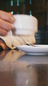 Man in caffee drinks coffee or tea
