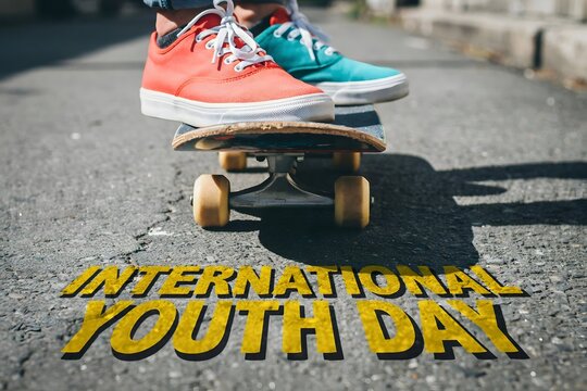 International youth day text overlay on skateboarder feet and asphalt