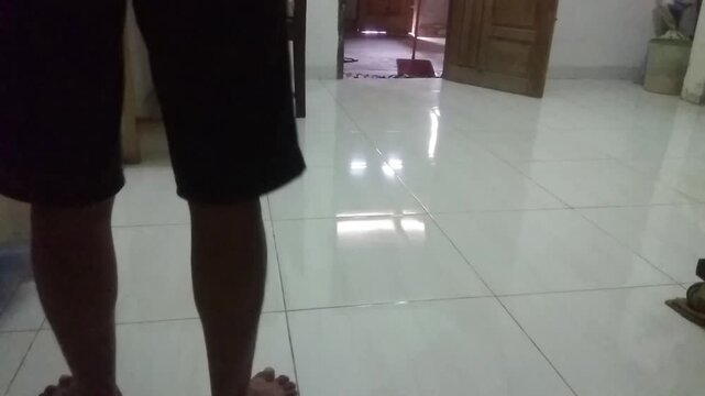 A man is sweeping the floor in a dirty, dusty family room, capturing a moment of cleanliness and tidiness amidst a cozy atmosphere.