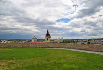 Obraz premium Historic Castle Walls and Green Lawn at Eger Castle Under Dramatic Cloudy Sky