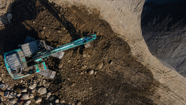 Aerial Scenery of Excavator Operating in Rock Quarry Mine with Gravel and Boulder Extraction, Construction and mining site view from above.