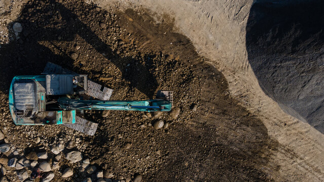 Aerial Scenery of Excavator Operating in Rock Quarry Mine with Gravel and Boulder Extraction, Construction and mining site view from above.
