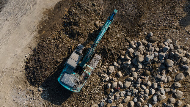 Aerial Scenery of Excavator Operating in Rock Quarry Mine with Gravel and Boulder Extraction, Construction and mining site view from above.