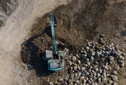 Aerial Scenery of Excavator Operating in Rock Quarry Mine with Gravel and Boulder Extraction, Construction and mining site view from above.